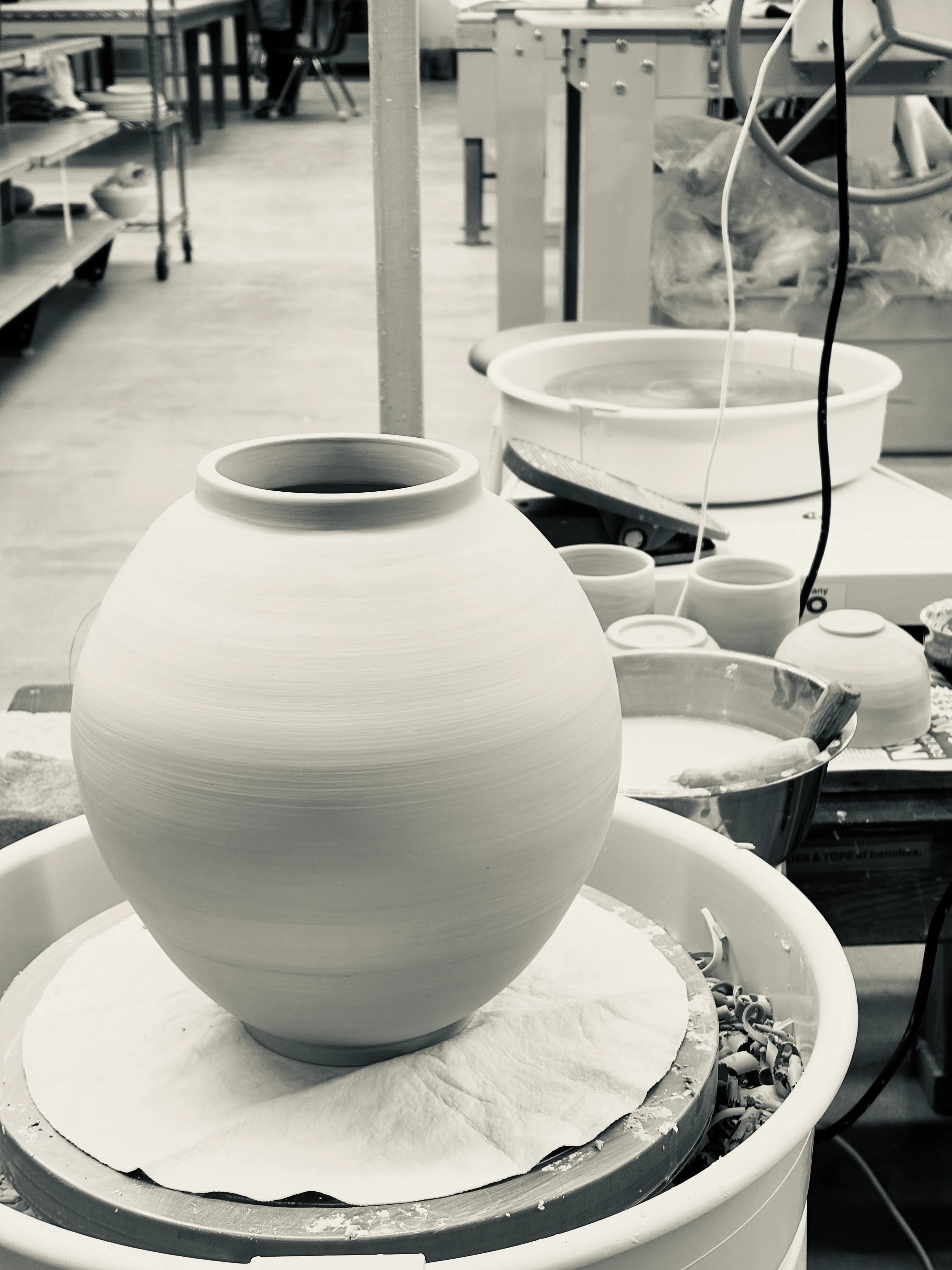 A freshly thrown moon jar drying on the wheel in the studio