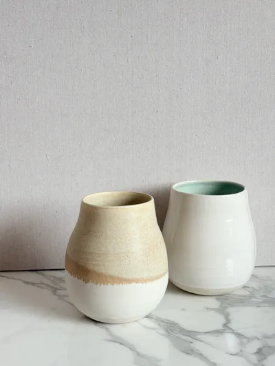 Two tumblers — one with an amber drip glaze, one lined in celadon